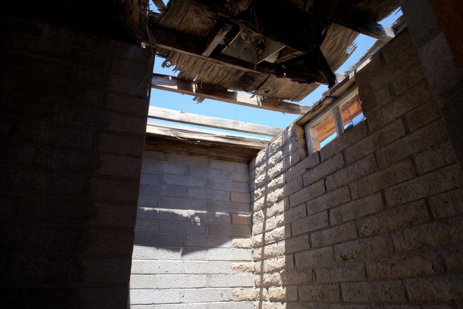 Trou dans une toiture vu depuis l’intérieur du bâtiment, le ciel apparaît
