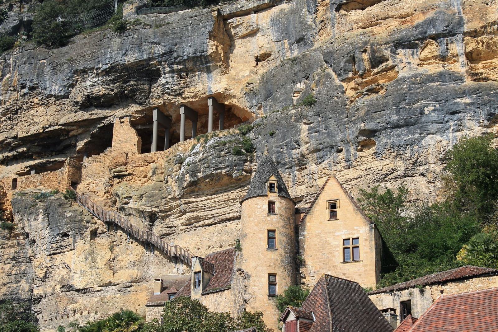 Village périgourdin aux maisons de pierre adossées à la falaise